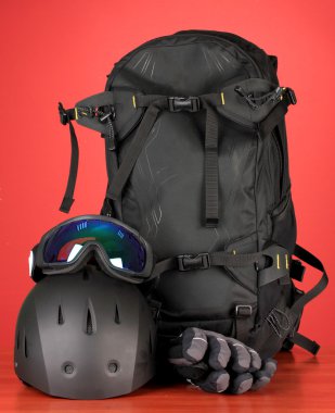 kış spor gözlük, kask ve eldivenler, sırt çantası, kırmızı zemin üzerine