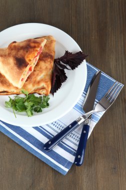 Pizza calzone peçete ahşap masa üzerinde plaka üzerinde