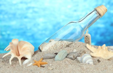 cam şişe içinde not parlak mavi arka plan ile