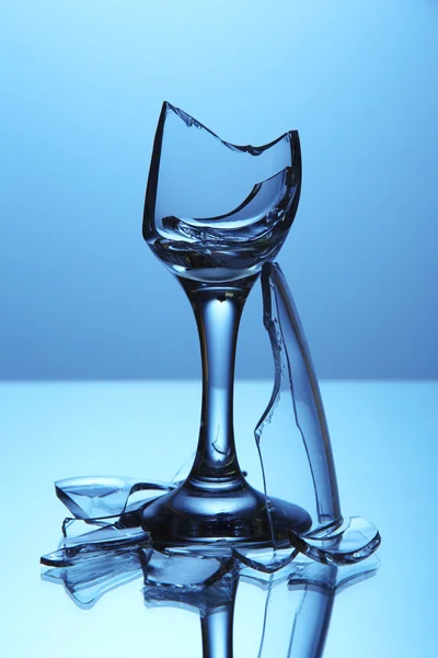 파란색 배경에 깨진된 와인 글라스 — 스톡 사진