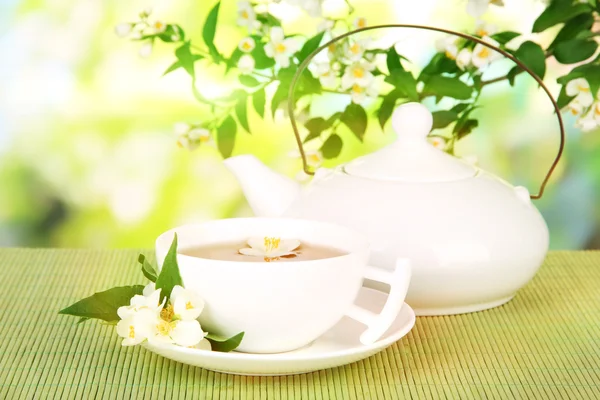 Šálek čaje s Jasmínou, na bambusové rohoži na světlé pozadí — Stock fotografie