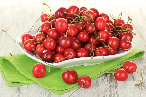 Kirschbeeren auf Teller auf Holztisch aus nächster Nähe — Stockfoto