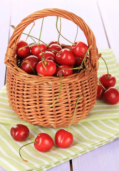 Kirschbeeren im Weidenkorb auf Holztisch aus nächster Nähe — Stockfoto