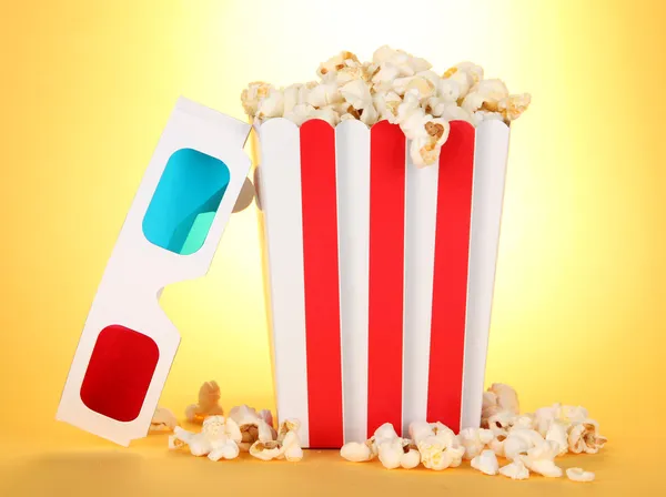 Popcorn et lunettes 3D sur fond jaune — Photo