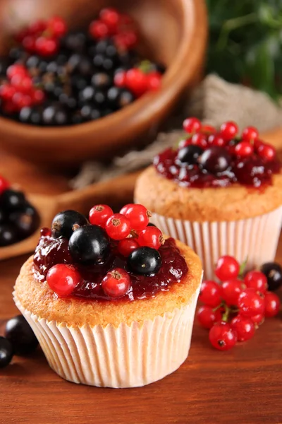 Leckere Muffins mit Beeren auf Holztisch — Stockfoto