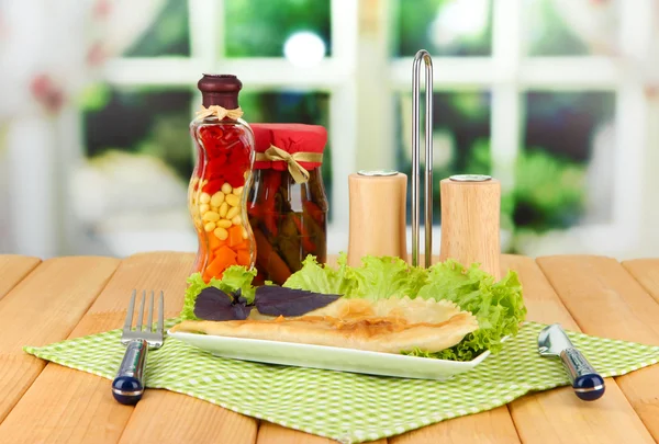 Leckere Chebureks mit frischen Kräutern auf Teller, Holztisch, auf hellem Hintergrund — Stockfoto