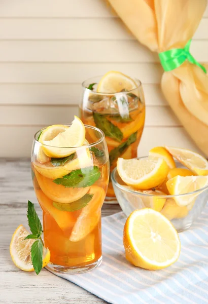 Холодный чай с лимоном и мятой на деревянном столе — стоковое фото