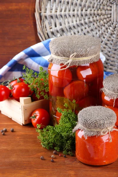 Смачні консервовані та свіжі помідори на дерев'яному столі — стокове фото