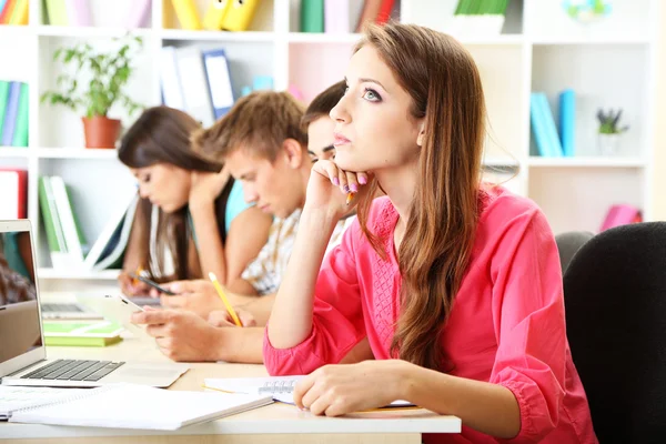 Group of young students sitting at the library — Stock Photo, Image