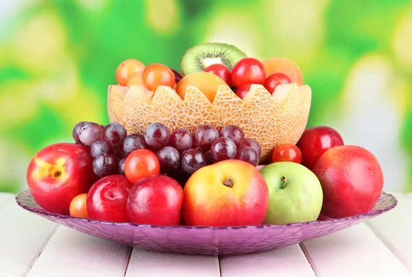 Sortimento de frutas suculentas na mesa de madeira, no fundo brilhante — Fotografia de Stock