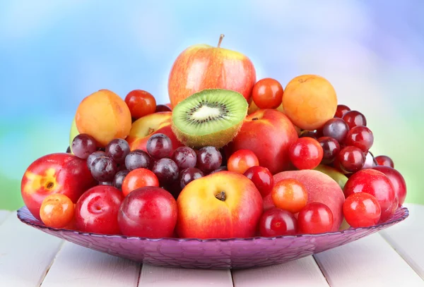 Sortimento de frutas suculentas na mesa de madeira, no fundo brilhante — Fotografia de Stock