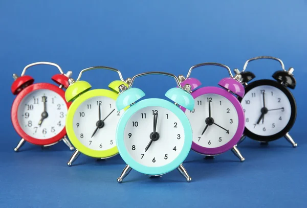 Reloj despertador colorido sobre fondo azul — Foto de Stock