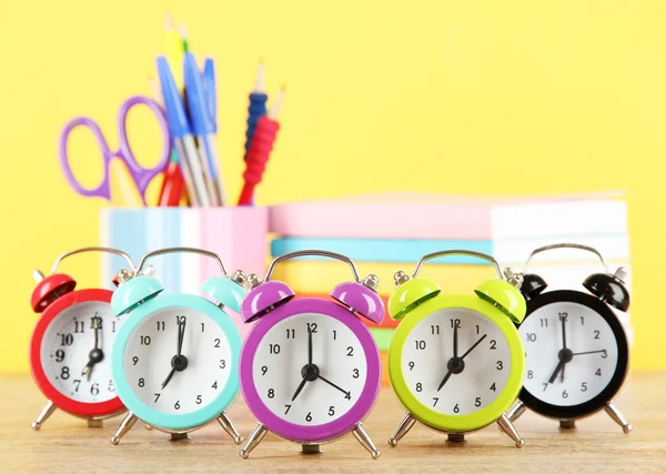 Färgglada väckarklocka på bordet på gul bakgrund — Stockfoto