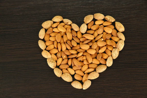 Almond on dark wooden background — Stock Photo, Image