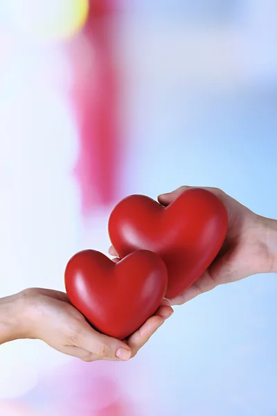 Hearts in hands on light background — Stock Photo, Image