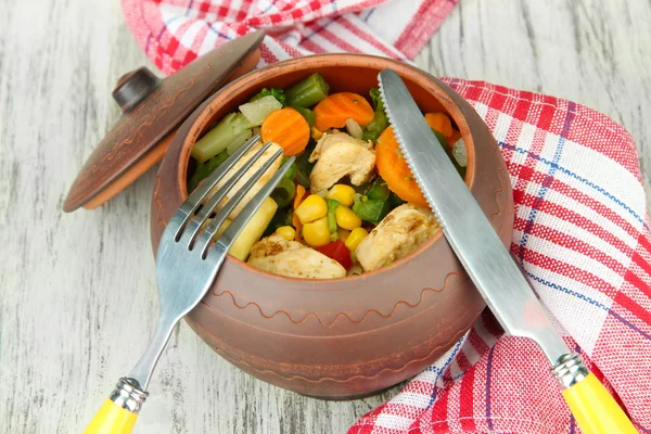 Gebakken gemengde groenten met kipfilet in pot, op houten achtergrond — Stockfoto