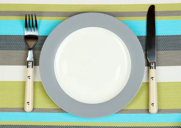 Messer, Farbteller und Gabel, auf farbigem Hintergrund — Stockfoto