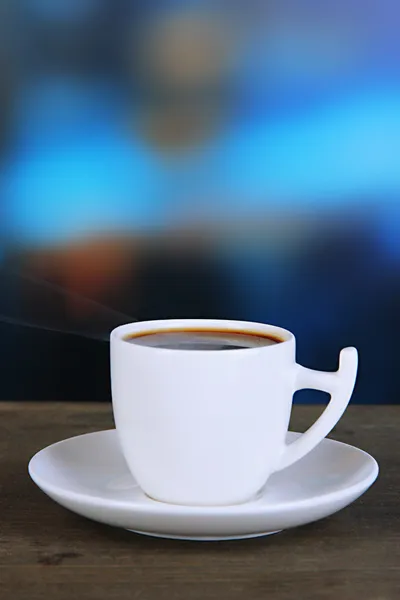 Чашка кофе на деревянном столе на ярком фоне — стоковое фото