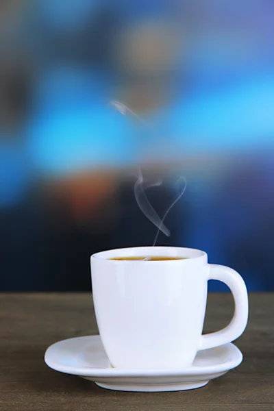 Cup of coffee on wooden table on bright background — Stock Photo, Image