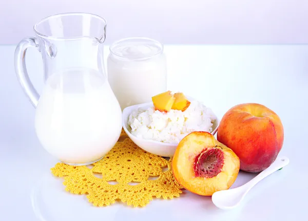 Fresh dairy products with peaches isolated on white — Stock Photo, Image