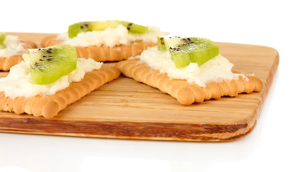 Хрустящий хлеб с сыром и киви, на разделочной доске, изолированный на белом — стоковое фото