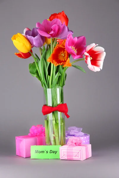 Belles tulipes en bouquet avec cadeaux et note sur fond gris — Photo
