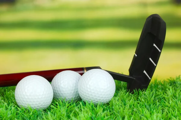 Pelotas de golf y conductor en césped verde al aire libre de cerca — Foto de Stock