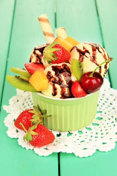 Вкусное мороженое с фруктами и ягодами в миске на деревянном столе — стоковое фото