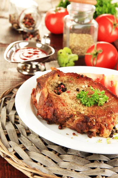 Stekt köttbit på plattan på träbord närbild — Stockfoto