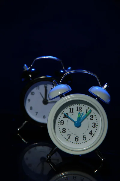 Dois relógios de alarme de estilo antigo no fundo de cor escura — Fotografia de Stock