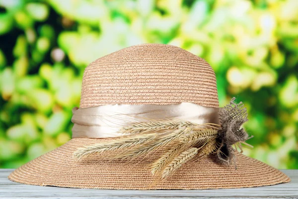 Hermoso sombrero de verano con espiguillas sobre fondo verde — Foto de Stock