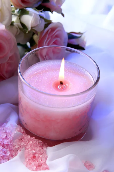 Beautiful candle with flower on white cloth, close up — Stock Photo, Image