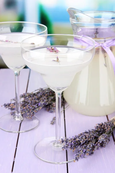Lavendel limonade in glas kruik en cocktail bril, op lichte achtergrond — Stockfoto