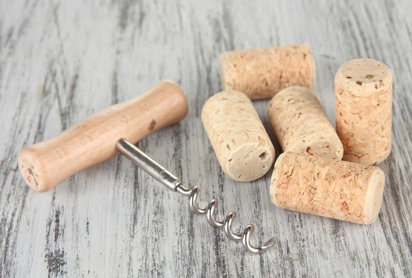 Corkscrew with wine corks on wooden table close-up — Stock Photo, Image