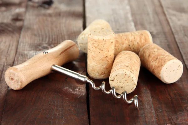 Corkscrew with wine corks on wooden table close-up — Stock Photo, Image