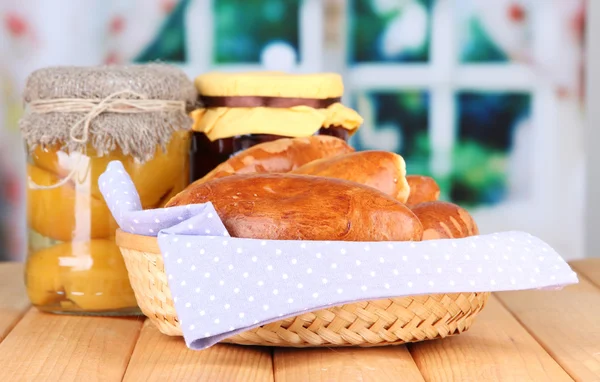 Fresh baked pasties with fruit jam, on wooden table, on bright background — Stock Photo, Image