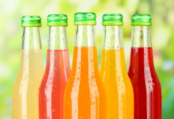 Bottles with tasty drinks on bright background — Stock Photo, Image