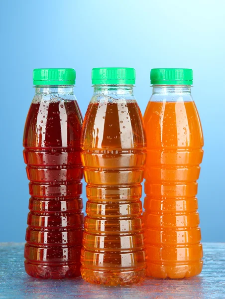 Assortment of bottles with tasty fruit juices on bright background — Stock Photo, Image