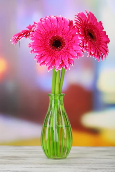 Beautiful pink gerbera flowers in vase on wooden table — Stock Photo, Image