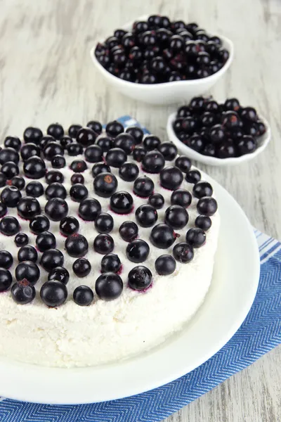 Tarta de queso con bayas frescas en plato blanco en primer plano de mesa de madera — Foto de Stock