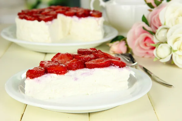 木製のテーブルの上の白い皿に新鮮なイチゴのチーズケーキ — ストック写真