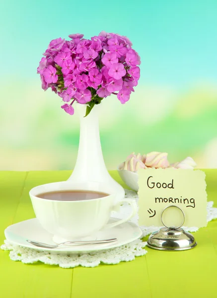 福禄与杯茶上光背景表格的美丽花束 — 图库照片