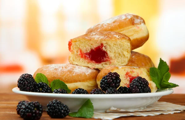 Leckere Donuts mit Beeren auf Holztisch — Stockfoto