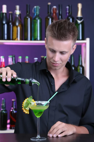 Portrait of handsome barman preparing cocktail, at bar — Stock Photo, Image