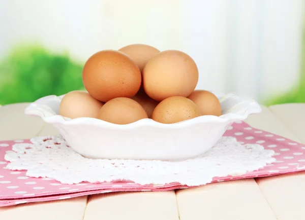 Eier im Teller auf Holztisch auf natürlichem Hintergrund — Stockfoto