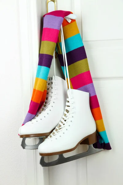 Figuur schaatsen opknoping op een deurknop met sjaal — Stockfoto