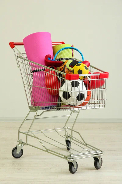 Carro de compras con equipo deportivo, sobre fondo gris —  Fotos de Stock