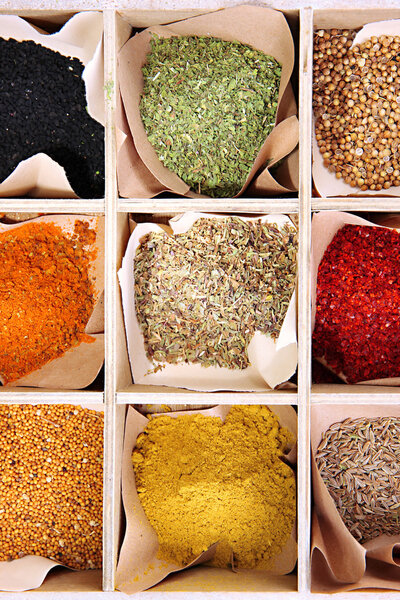 Ассортимент специй в деревянной коробке, крупным планом
