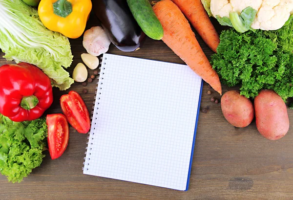 Świeże warzywa i przyprawy i papier do notatki, na tle drewniane — Zdjęcie stockowe