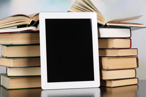 Tablet and books on light background — Stock Photo, Image